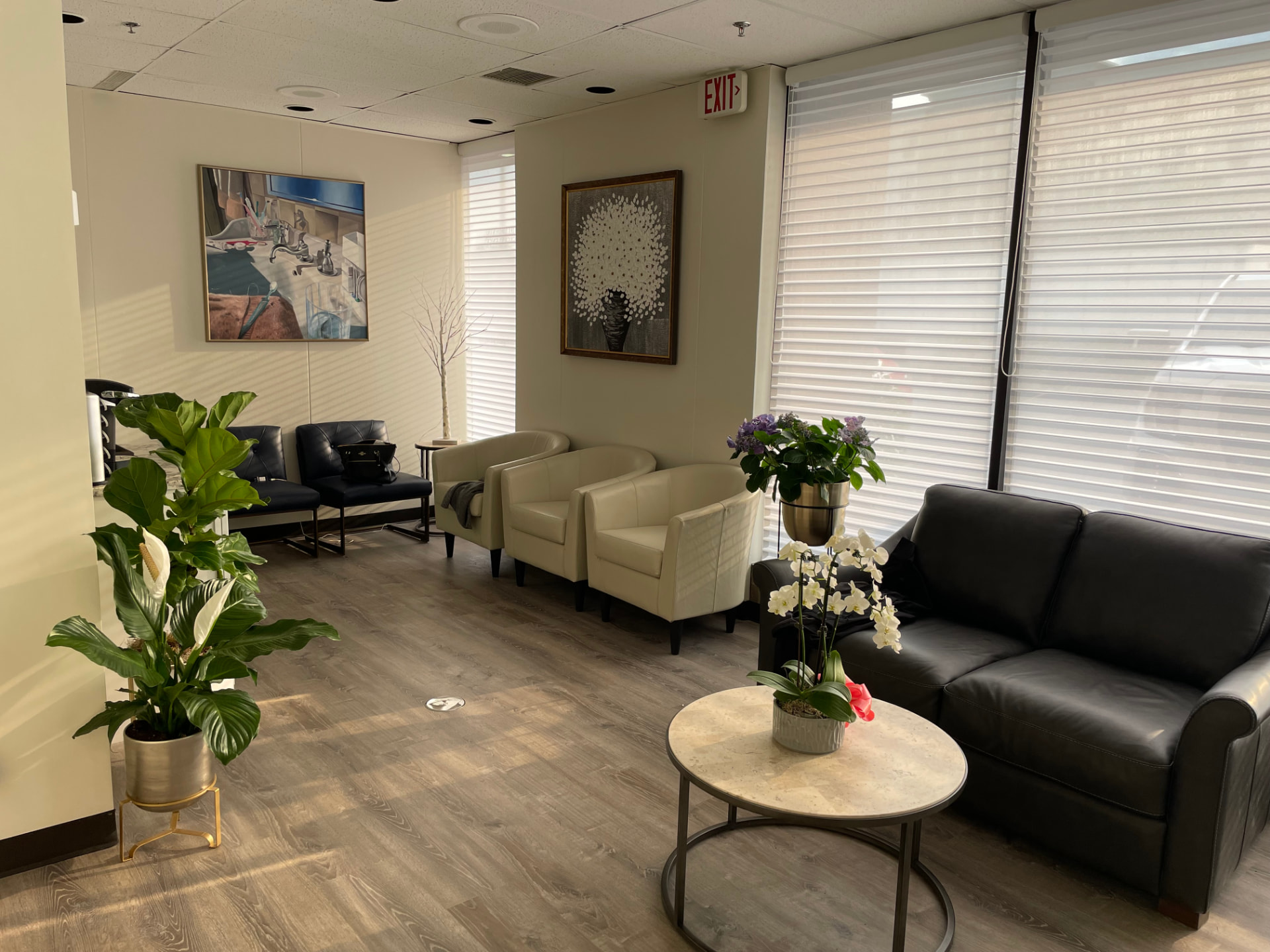 Seating area with armchairs, fresh flowers, and artwork at our Westchester dental office