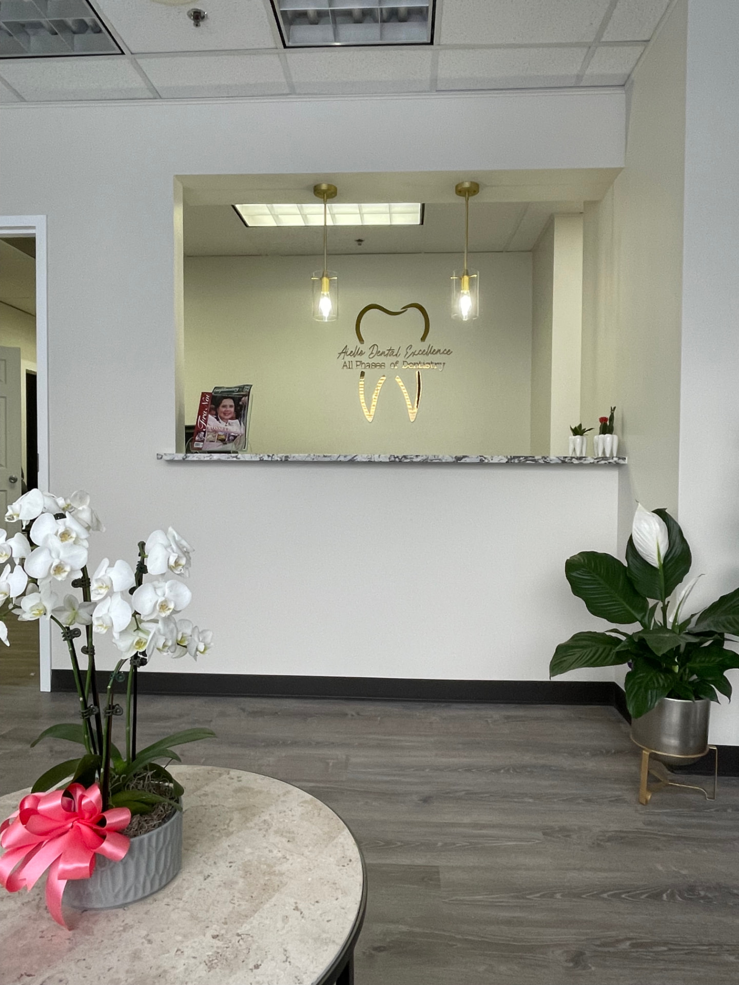 Aiello Dental Excellence reception window with the practice logo in Westchester, IL